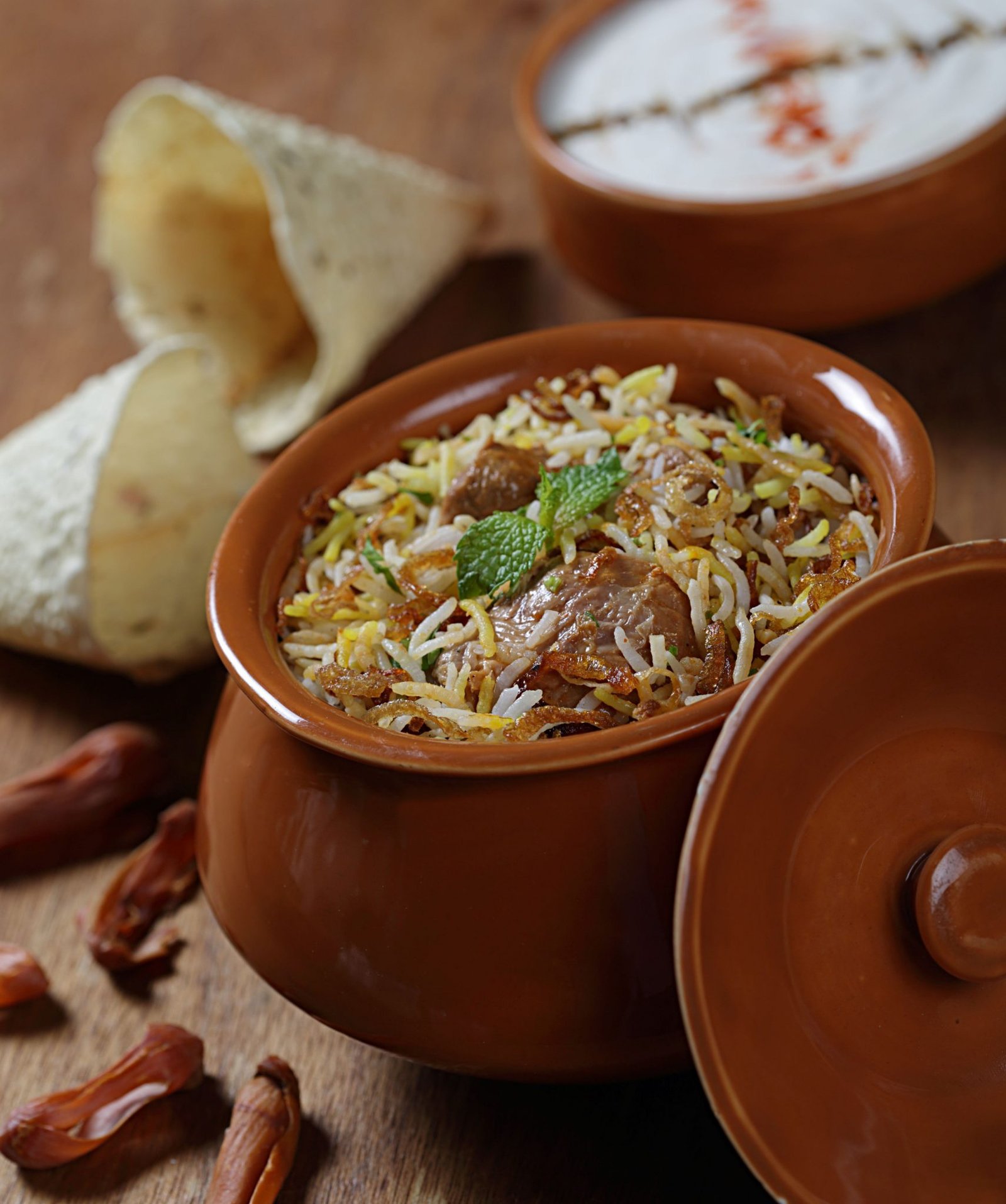 Hyderabadi chicken dum biryani with saffron rice in a handi