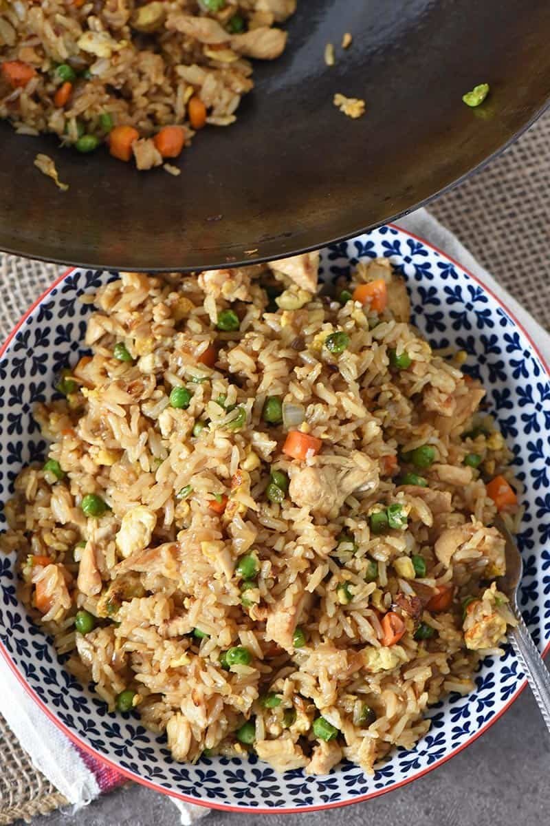 Chicken fried rice in a wok with egg and scallions