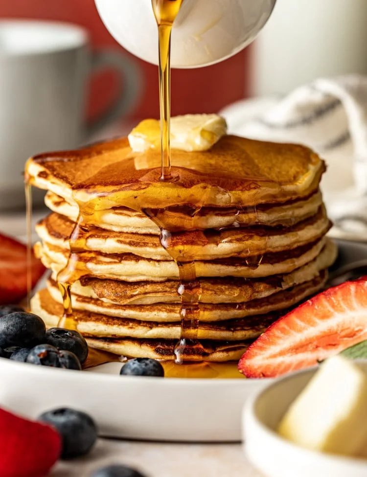 Stack of fluffy buttermilk pancakes with maple syrup